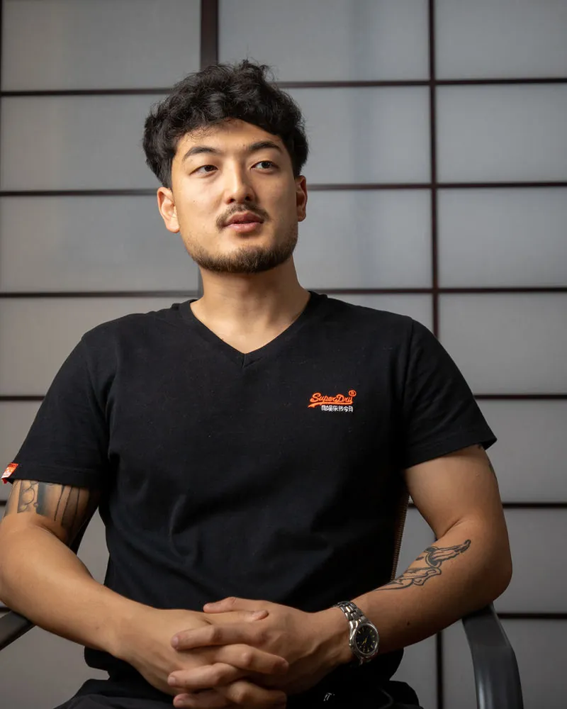 Harrison Saito seated beside a shoji screen in traditional Japanese light