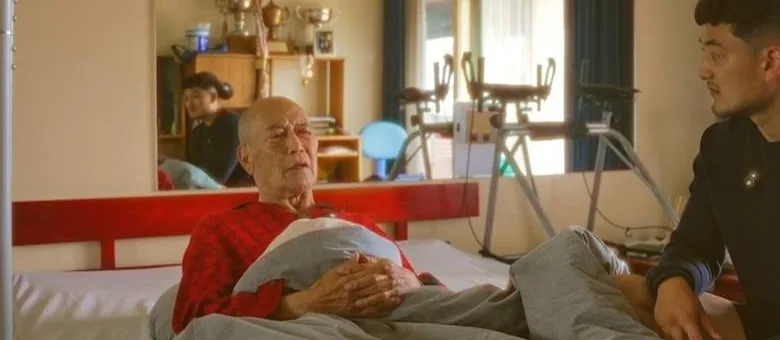 Harrison Saito seated at his father's bedside