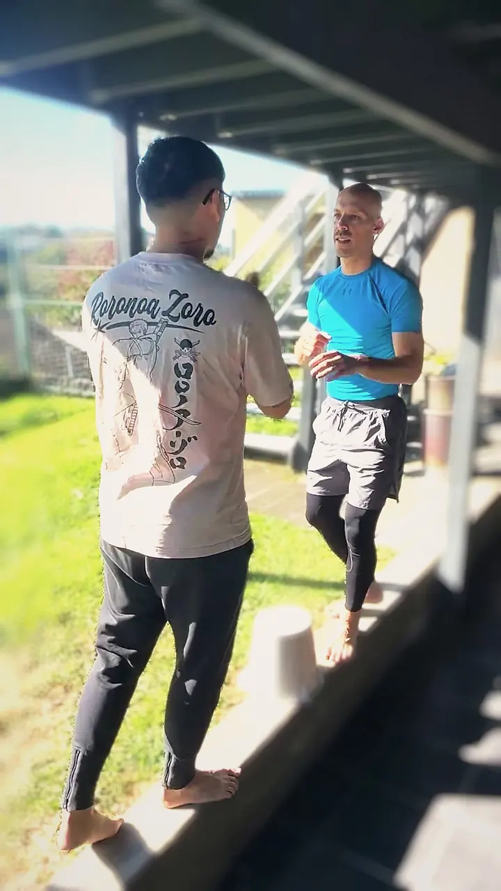Harrison steadying a client through a balance drill outdoors